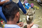 Man sculpting a stone mask with tools