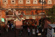 Busy market entrance with people and stalls.
