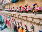 Colorful handcrafted camel figurines displayed for sale.