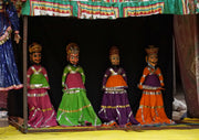 Four colorful puppets stand on a stage.