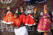 Colorful traditional indian puppets displayed at a market.